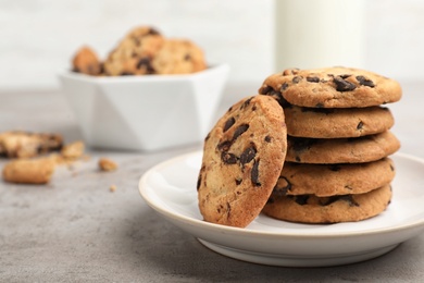 Photo of Plate with tasty chocolate cookies on gray table