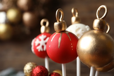 Delicious Christmas ball cake pops on blurred background, closeup