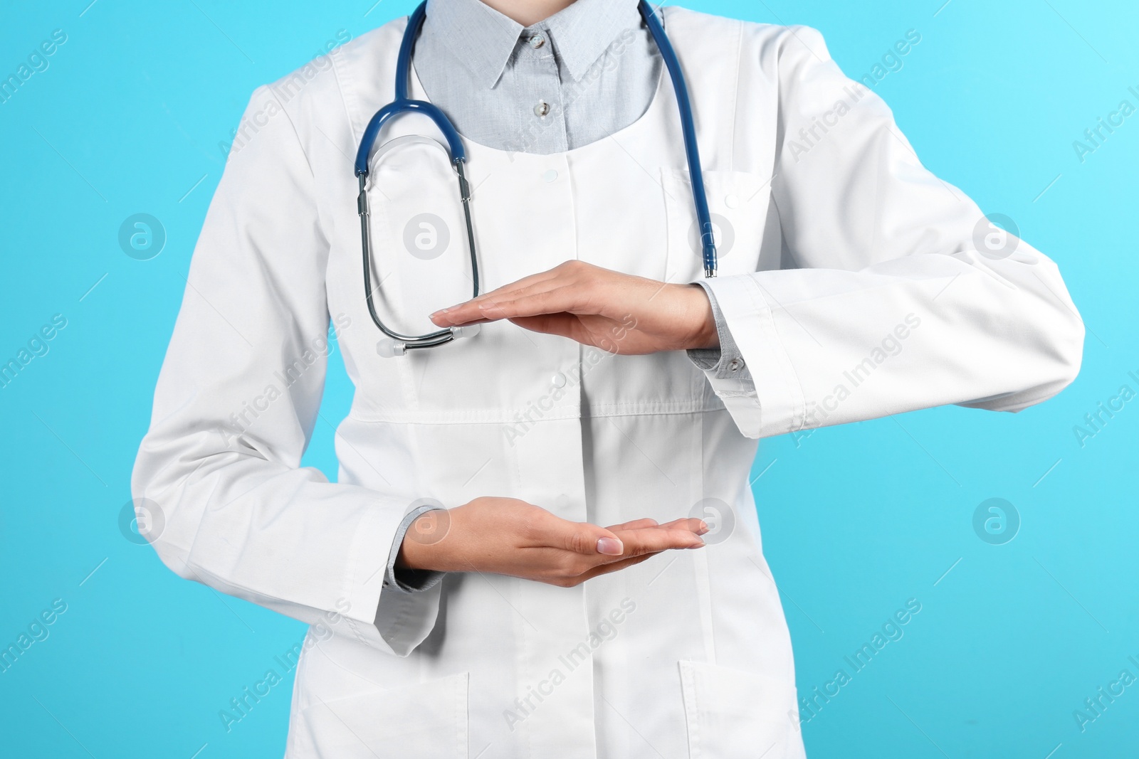 Photo of Female doctor holding something on color background, closeup