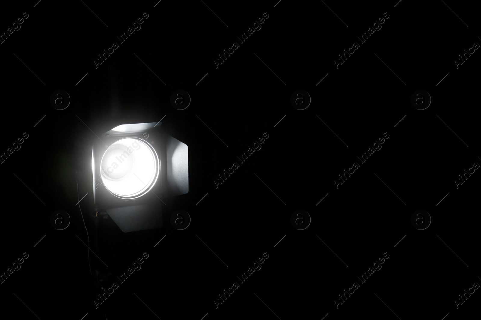 Photo of Bright spotlight in darkness, space for text. Professional stage equipment