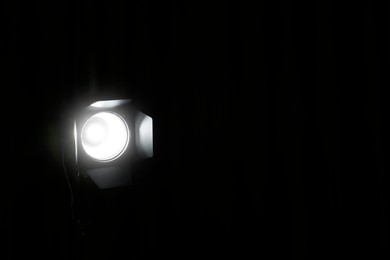 Bright spotlight in darkness, space for text. Professional stage equipment