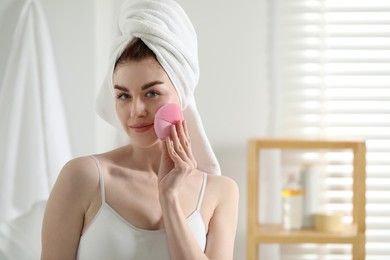 Washing face. Young woman with cleansing brush indoors, space for text