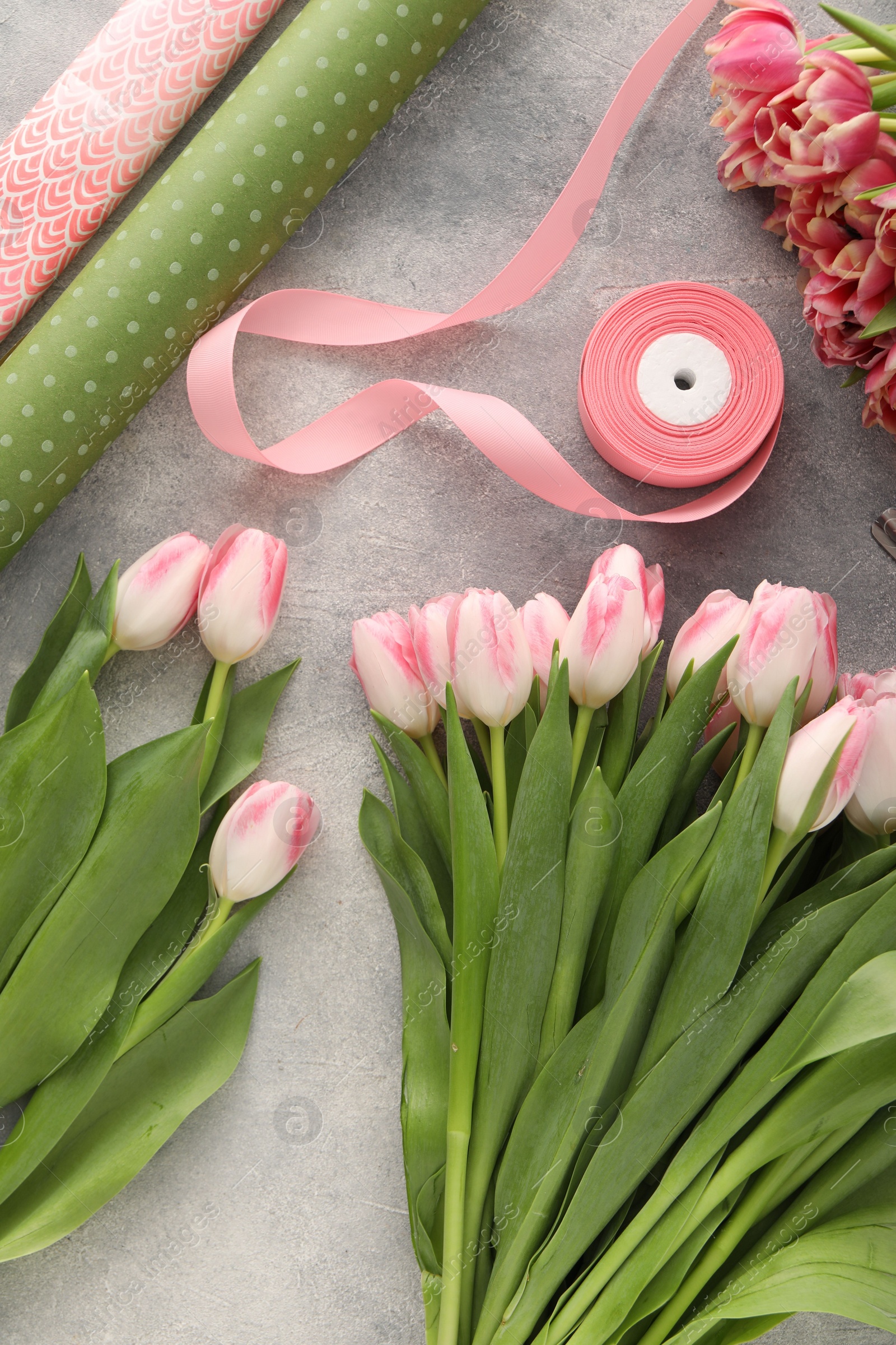 Photo of Beautiful pink tulips on grey table, flat lay