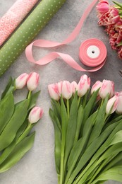 Beautiful pink tulips on grey table, flat lay