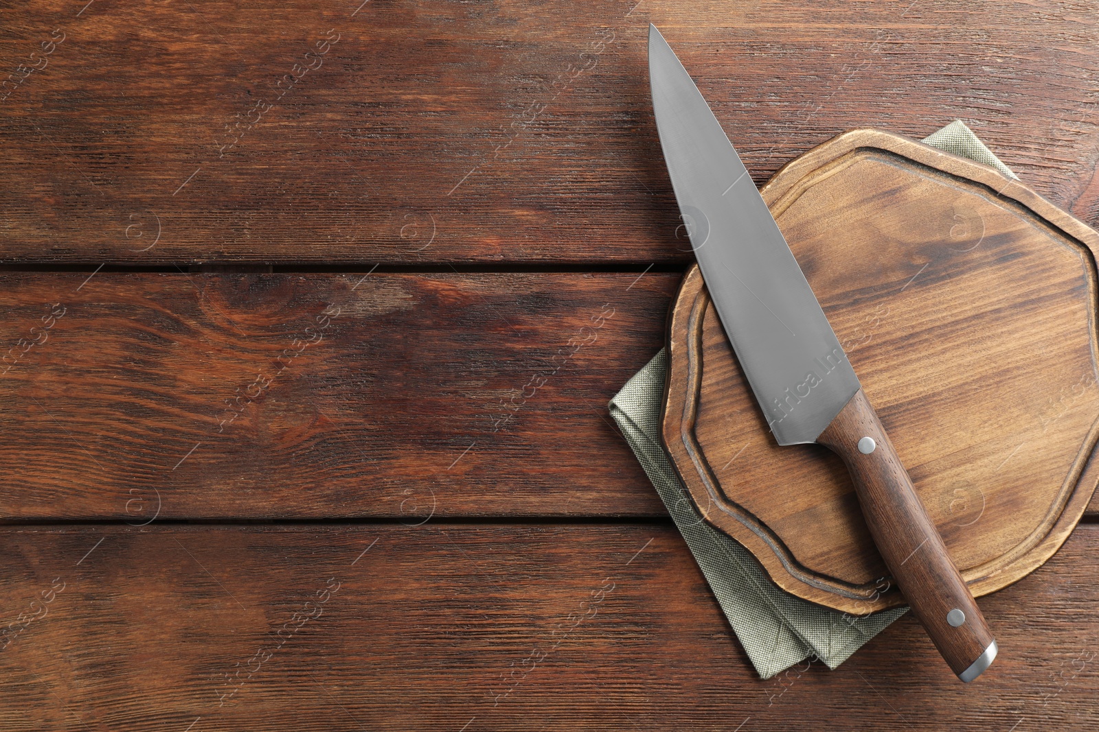 Photo of One sharp knife and board on wooden table, top view. Space for text