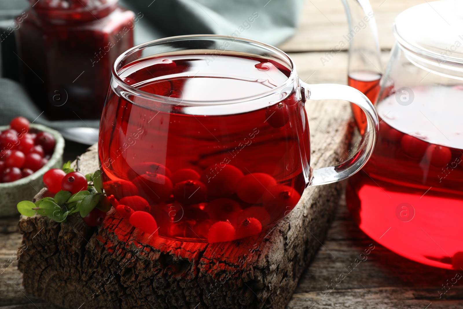 Photo of Delicious cranberry tea and berries on wooden table, closeup