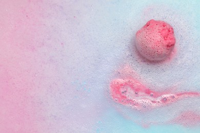 Pink bath bomb dissolving in water. Space for text