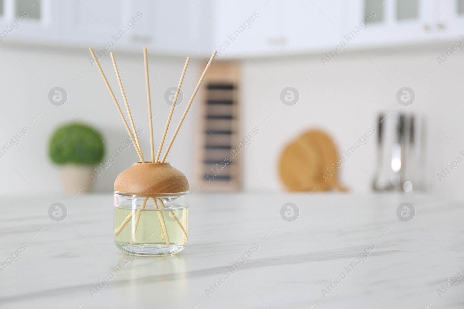 Photo of Aromatic reed air freshener on white marble table indoors. Space for text