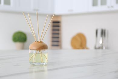 Aromatic reed air freshener on white marble table indoors. Space for text