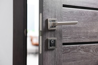 Open wooden door with metal handle, closeup