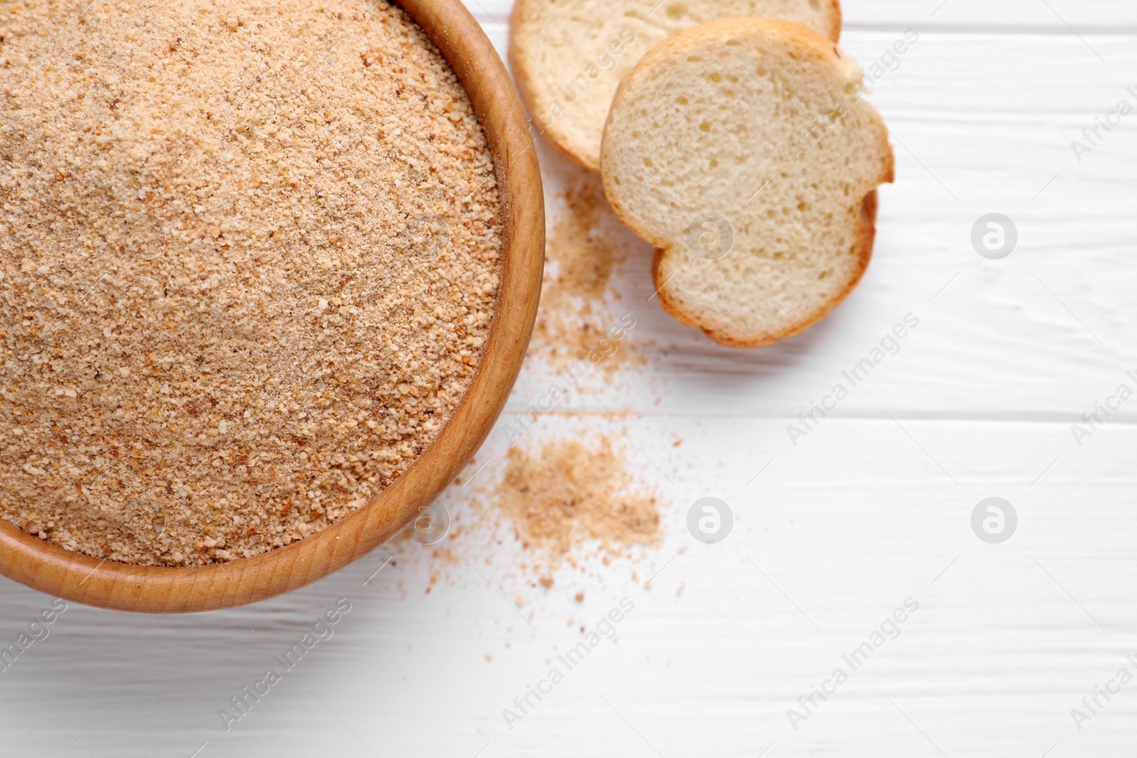 Photo of Fresh breadcrumbs on white wooden table, flat lay