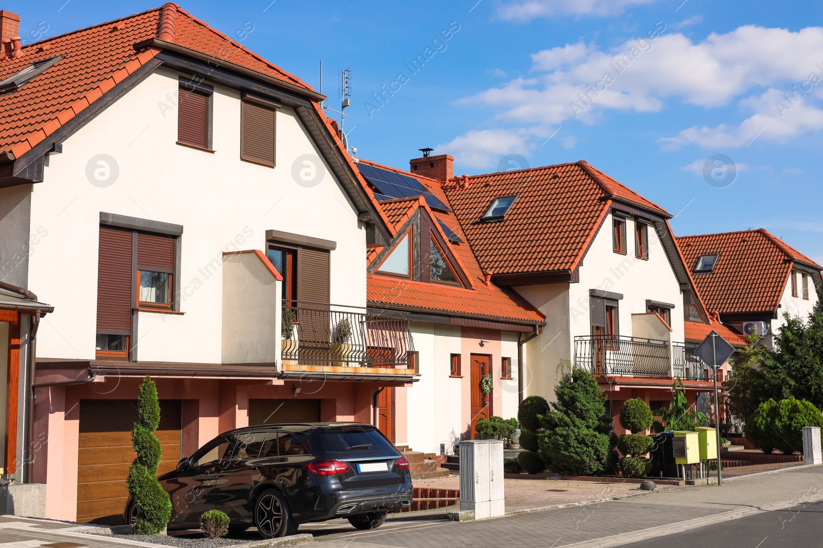 Photo of Block of houses with parked car outdoors on sunny day