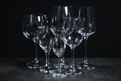 Photo of Set of bar glassware on table against dark background