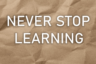Image of Phrase NEVER STOP LEARNING on brown crumpled paper