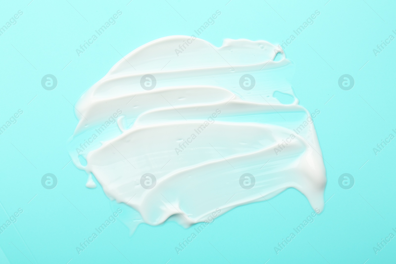 Photo of Face cream on light blue background, top view