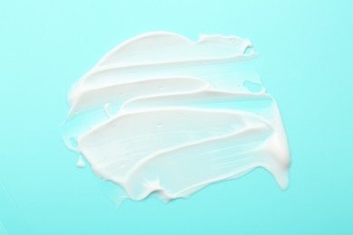 Photo of Face cream on light blue background, top view