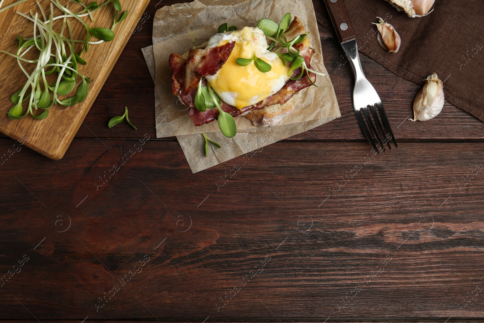 Photo of Delicious egg Benedict served on wooden table, flat lay. Space for text