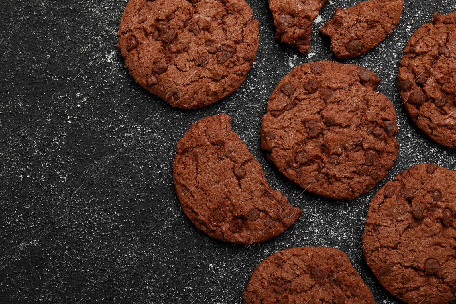 Photo of Tasty chocolate cookies on grey textured table, flat lay. Space for text