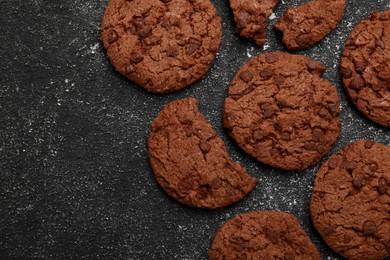 Photo of Tasty chocolate cookies on grey textured table, flat lay. Space for text