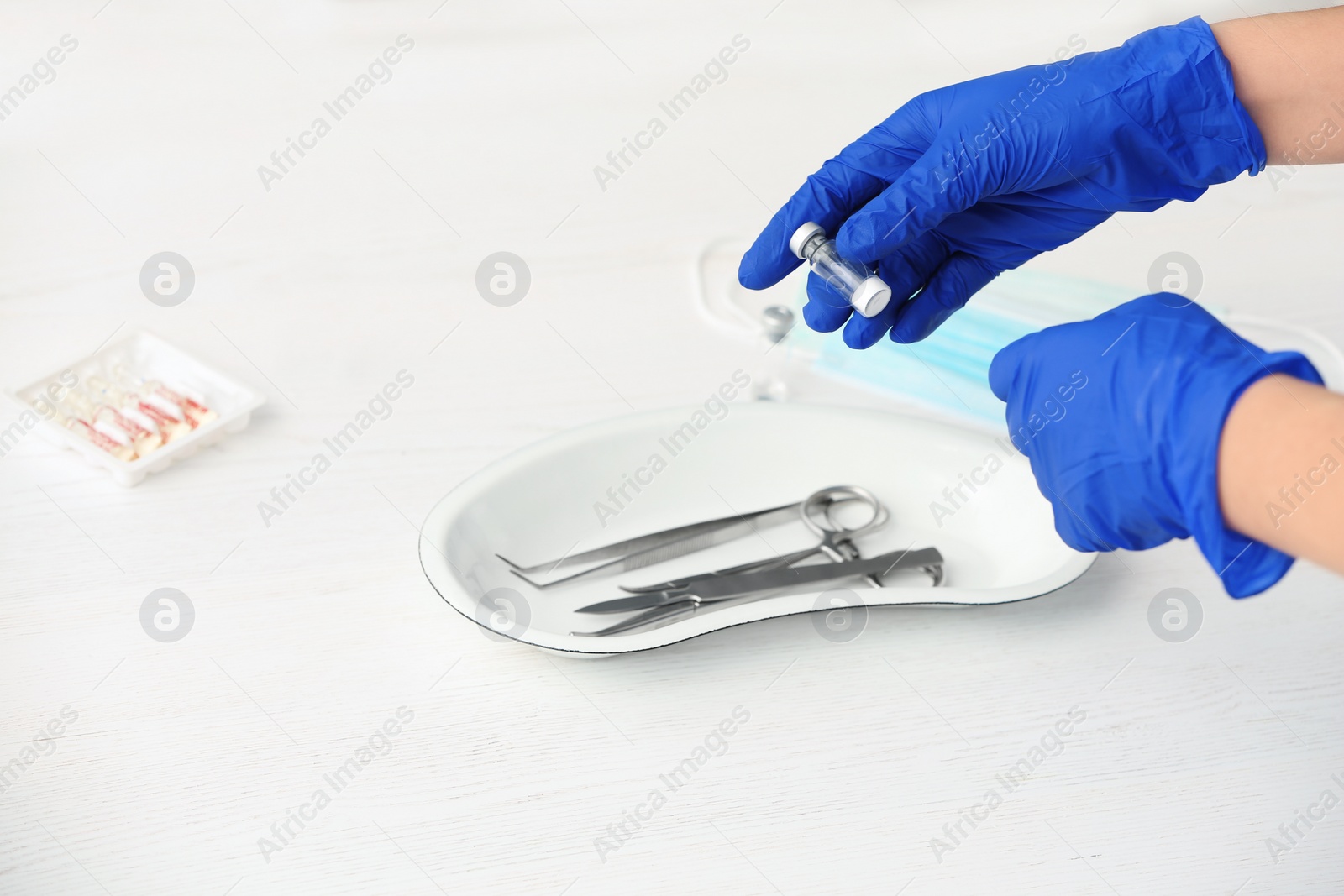 Photo of Doctor in medical gloves with vial at table