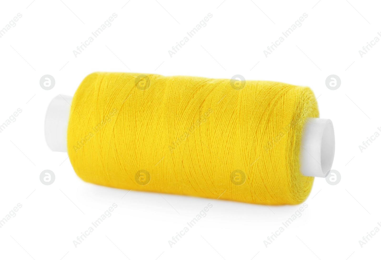 Photo of Spool of yellow sewing thread isolated on white