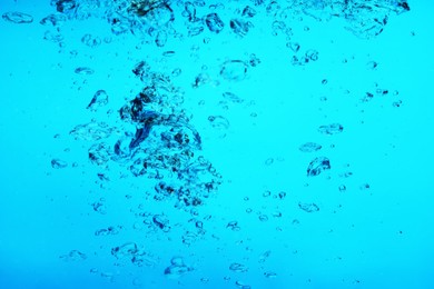 Image of Many air bubbles in water on light blue background