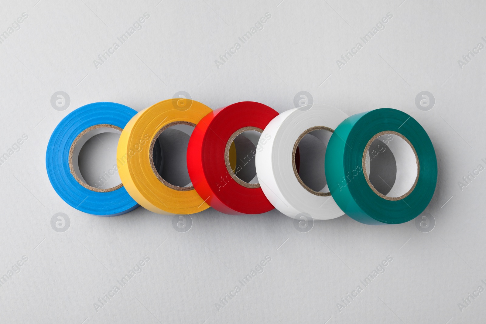 Photo of Colorful insulating tapes on white background, flat lay