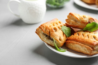 Photo of Fresh delicious puff pastry served on light table, closeup