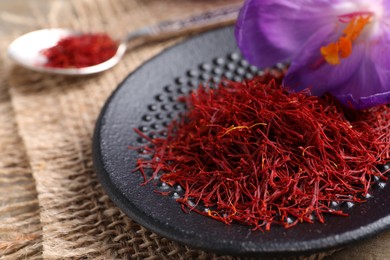 Photo of Dried saffron and crocus flowers on table, closeup