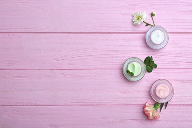 Photo of Jars with body cream on wooden background