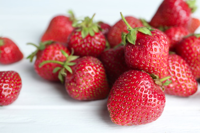 Photo of Delicious ripe strawberries on white wooden table, closeup