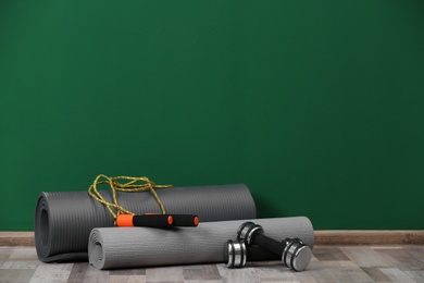 Photo of Set of fitness equipment on floor near color wall. Space for text
