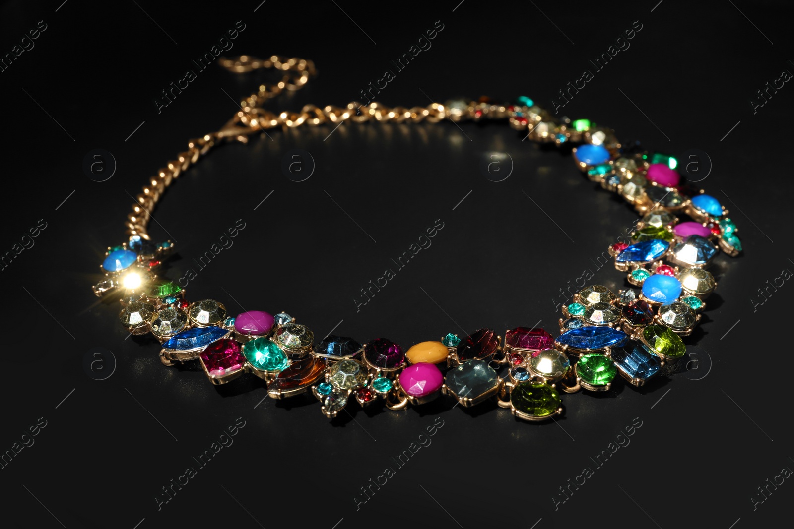 Photo of Stylish necklace with gemstones on black background. Luxury jewelry