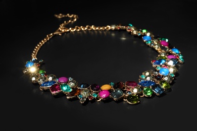 Stylish necklace with gemstones on black background. Luxury jewelry
