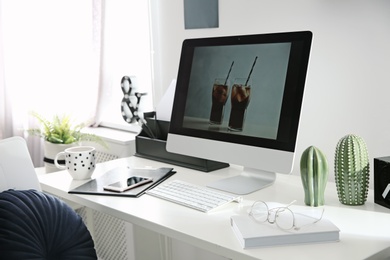 Photo of Comfortable workplace with computer on desk in home office