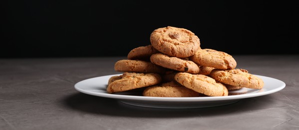 Photo of Tasty cookies on grey textured table, closeup