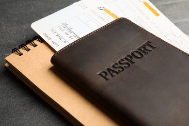 Passport, tickets and notebook on grey background, closeup. Travel agency