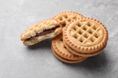 Photo of Tasty sandwich cookies with cream on grey table, closeup