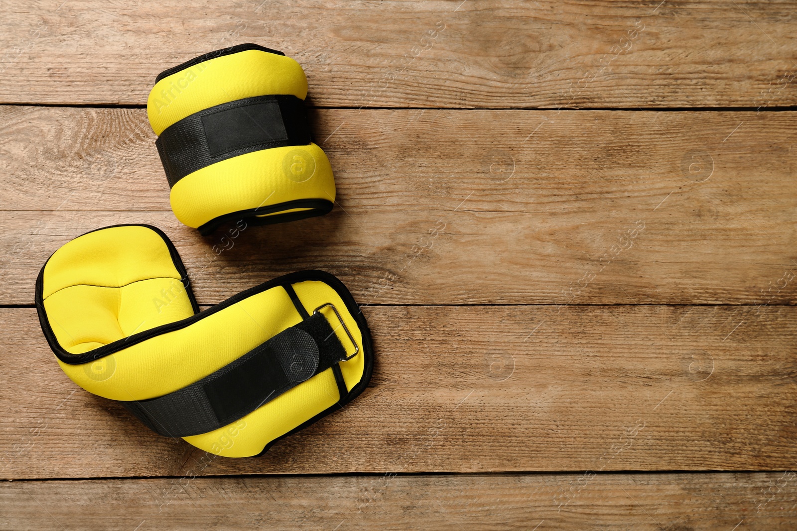 Photo of Yellow weighting agents on wooden table, flat lay. Space for text