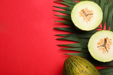 Photo of Composition with ripe tasty melons on red background, flat lay. Space for text