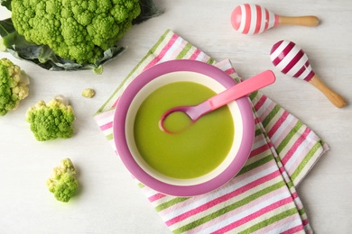 Flat lay composition with plate of healthy baby food on light background