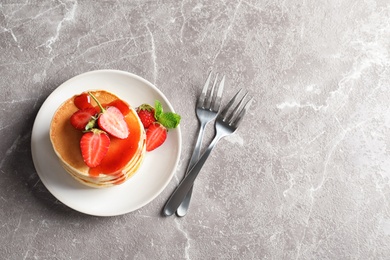 Photo of Plate with pancakes and berries on grey background, top view