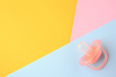 Photo of New baby pacifier on color background, top view. Space for text
