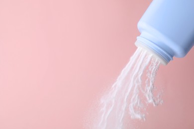 Photo of Scattering of baby powder on pink background, closeup. Space for text