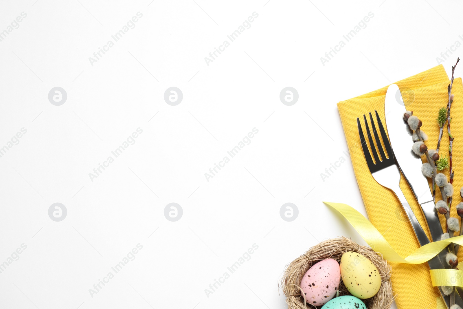 Photo of Top view of cutlery set with floral decor for Easter celebration on white background