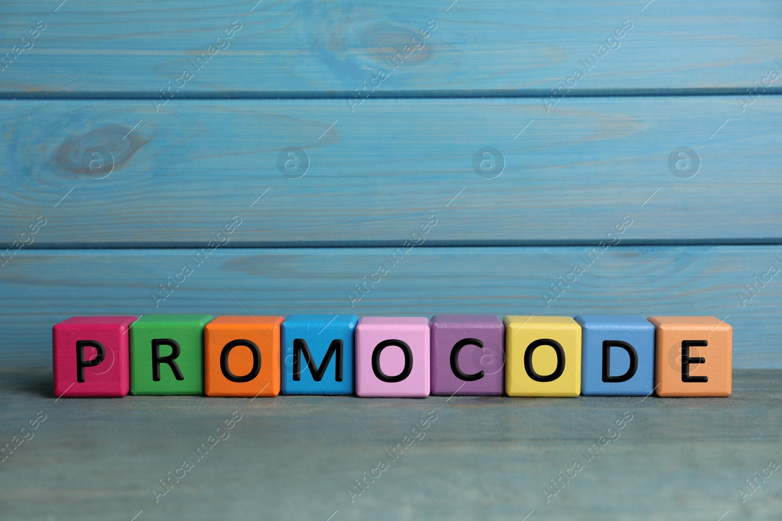 Photo of Colorful cubes with words Promo Code on grey table, space for text