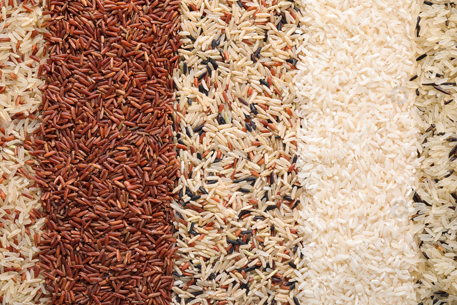 Photo of Different types of rice as background, top view