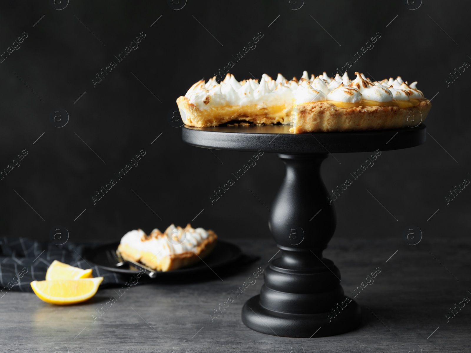 Photo of Stand with delicious lemon meringue pie on dark grey table, space for text