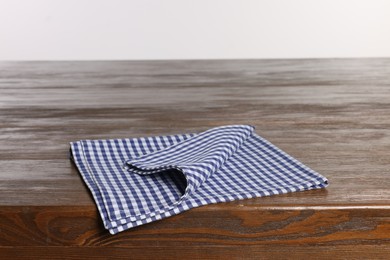 Checkered tablecloth on wooden table against white background