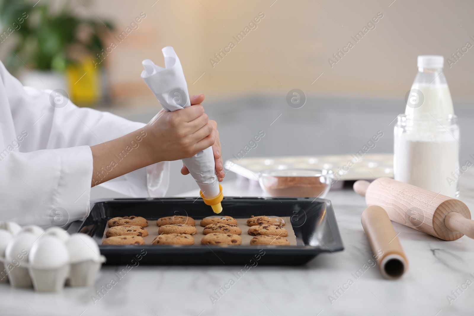 Photo of Female chef preparing biscuits at kitchen table, closeup. Cooking delicious food